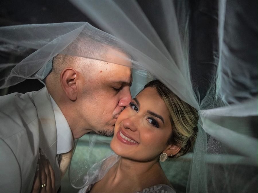 Noivos se beijando sob o véu logo depois da cerimônia